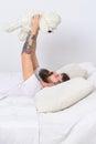 Macho with beard and mustache relaxing with plush toy after nap. Childhood memories concept. Guy on smiling face playing Royalty Free Stock Photo