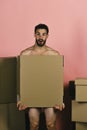 Macho with beard and surprised face covering himself with box