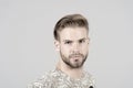 Macho with bearded face, beard. Man with blond hair, haircut. Grooming and hair care in beauty salon, barbershop Royalty Free Stock Photo