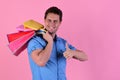 Macho in blue shirt with packages in hand.