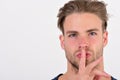 Macho with confident face holds finger near lips