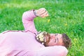 Macho with daisies in beard relaxing. Bearded man with daisy flowers in beard lay on grassplot, grass background. Peace Royalty Free Stock Photo