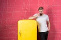 Macho drink at retro fridge on pink background. Man hold cup of tea or coffee in kitchen. Bachelor with morning drink at refrigera