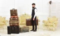 Macho elegant on strict face carries vintage suitcase. Luggage and relocation concept. Man, butler with beard and