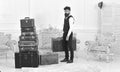 Macho elegant on strict face carries vintage suitcase. Luggage and relocation concept. Man, butler with beard and