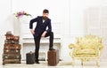 Macho elegant on thoughtful face standing near pile of vintage suitcase. Man, traveller with beard and mustache with