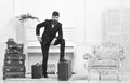 Macho elegant on thoughtful face standing near pile of vintage suitcase. Man, traveller with beard and mustache with