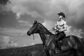 Macho man handsome cowboy and horse on the background of sky and water.