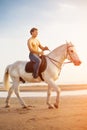 Macho man and horse on the background of sky and water. Boy mode Royalty Free Stock Photo