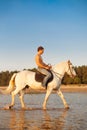 Macho man and horse on the background of sky and water. Boy mode Royalty Free Stock Photo