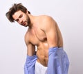 Macho with body takes off home or bath clothes. Royalty Free Stock Photo