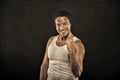 Macho on smiling face with strong muscles look brutal, black background. Man with muscular arms squeezing fist tight, as Royalty Free Stock Photo
