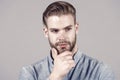 Macho with stylish hair touch beard with hand. Bearded man with healthy young skin. Guy with unshaven face and mustache Royalty Free Stock Photo