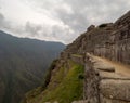 Machu Picchu Terraces and inca stone wall mountain range and clouds in the background Royalty Free Stock Photo