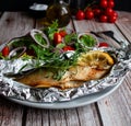 Mackerel baked in foil with vegetables on a plate. Royalty Free Stock Photo