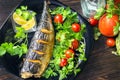 Mackerel baked with lemon. Fish on a plate with vegetables Royalty Free Stock Photo