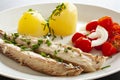 Mackerel fish dish with potatoes, chives and tomato salad. Fatty, oily fish is an excellent and healthy source of DHA and EPA, whi