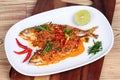 Mackerel fish fried topped a spicy curry on wood Royalty Free Stock Photo