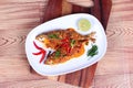 Mackerel fish fried topped spicy curry on wood Royalty Free Stock Photo