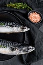 Mackerel fish with thyme and pink salt. Fresh seafood. Black background. Top view