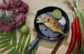 Mackerel fried in a frying pan on a wooden table Royalty Free Stock Photo