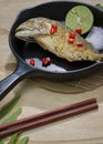 Mackerel fried in a frying pan on a wooden table Royalty Free Stock Photo
