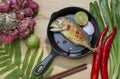 Mackerel fried in a frying pan on a wooden table Royalty Free Stock Photo