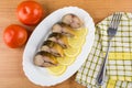 Mackerel, slices of lemon in dish, tomatoes and fork Royalty Free Stock Photo