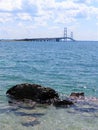 Mackinac Bridge Michigan with Rock near Shoreline in the Foreground beautiful bright Blue and Clear Water Mackinaw City Great Royalty Free Stock Photo