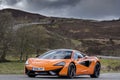 MacLaren supercar on an empty winding road Royalty Free Stock Photo