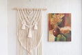 Macrame. Decoration for the interior. Interior design with beige beautiful macrame and canvas painting. Concept of cozy home