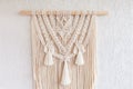 Macrame. Decoration for the interior. Interior design with beige beautiful macrame wallhanding. Concept of cozy home decor