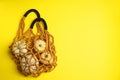 Macrame shopping bag with pumpkins on yellow background, top view. Space for text Royalty Free Stock Photo