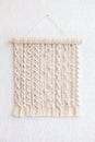 Macrame wallhanging with wooden beads. Wall panel of cotton threads in natural color. Macrame technique for eco home decor and