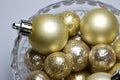 Macro abstract art background of glowing gold Christmas ornaments and balls with with glitter in a beautiful crystal bowl