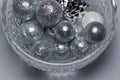 Macro abstract art texture of sparkling silver glitter Christmas ornaments and balls, in a crystal bowl on a white background Royalty Free Stock Photo