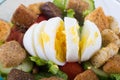 Closeup of boiled egg which was badly sliced on top of a salad