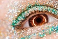 Macro brown female eye with glitter eyeshadow, colorful sparks, crystals. Beauty background, fashion glamour makeup Royalty Free Stock Photo