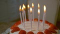 MACRO: Candles burn on top of a delicious strawberry-coconut birthday cake. Royalty Free Stock Photo