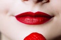 Macro close up of caucasus woman`s lips with red lipstick and fresh strawberry Royalty Free Stock Photo