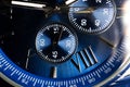 Macro Close Up of Complications and Roman Numeral Eight on Blue Faced Chronograph