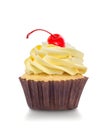 Macro close up of a cupcake with yellow cream and red cherry isolated on white background Royalty Free Stock Photo