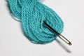 Macro close-up of needle is threaded into the thread of blue yarn