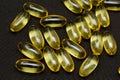 Macro Close up of Omega 3 gel capsule on a reflective black background Royalty Free Stock Photo