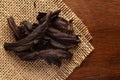 Macro close-up of Organic Alkanna tinctoria or ratan jot on the wooden top background and jute mat. Pile of Indian Aromatic Spice.