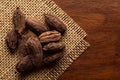 Macro close-up of Organic Black cardamom Amomum subulatum on the wooden top background and jute mat. Pile of Indian Aromatic