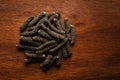 Macro close-up of Organic Indian long pepper Piper retrofractum on wooden top background. Pile of Indian Aromatic Spice.