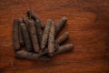 Macro close-up of Organic Indian long pepper Piper retrofractum on wooden top background. Pile of Indian Aromatic Spice.