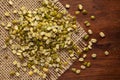 Macro Close-up of Organic split and unpolished Green Moong Dal Vigna radiata on Jute mat and wooden