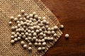 Macro close-up of Organic White peppercorns Piper nigrum on the wooden top background and jute mat. Pile of Indian Aromatic Spic